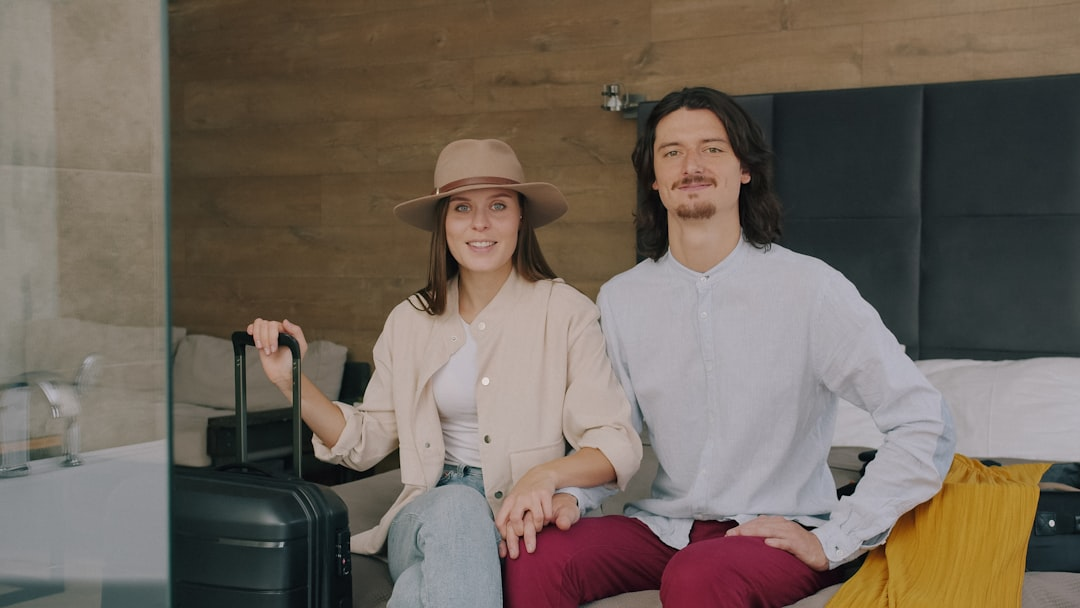 Travelers smiling with their suitcase in a hotel room